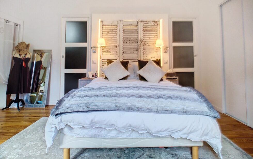 Tête de lit lumineuse faite main avec volets recyclés ddans chambre rénovée